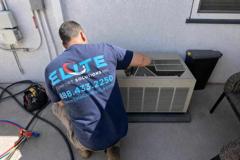 Elite Comfort Solutions technician servicing a packaged air conditioning unit