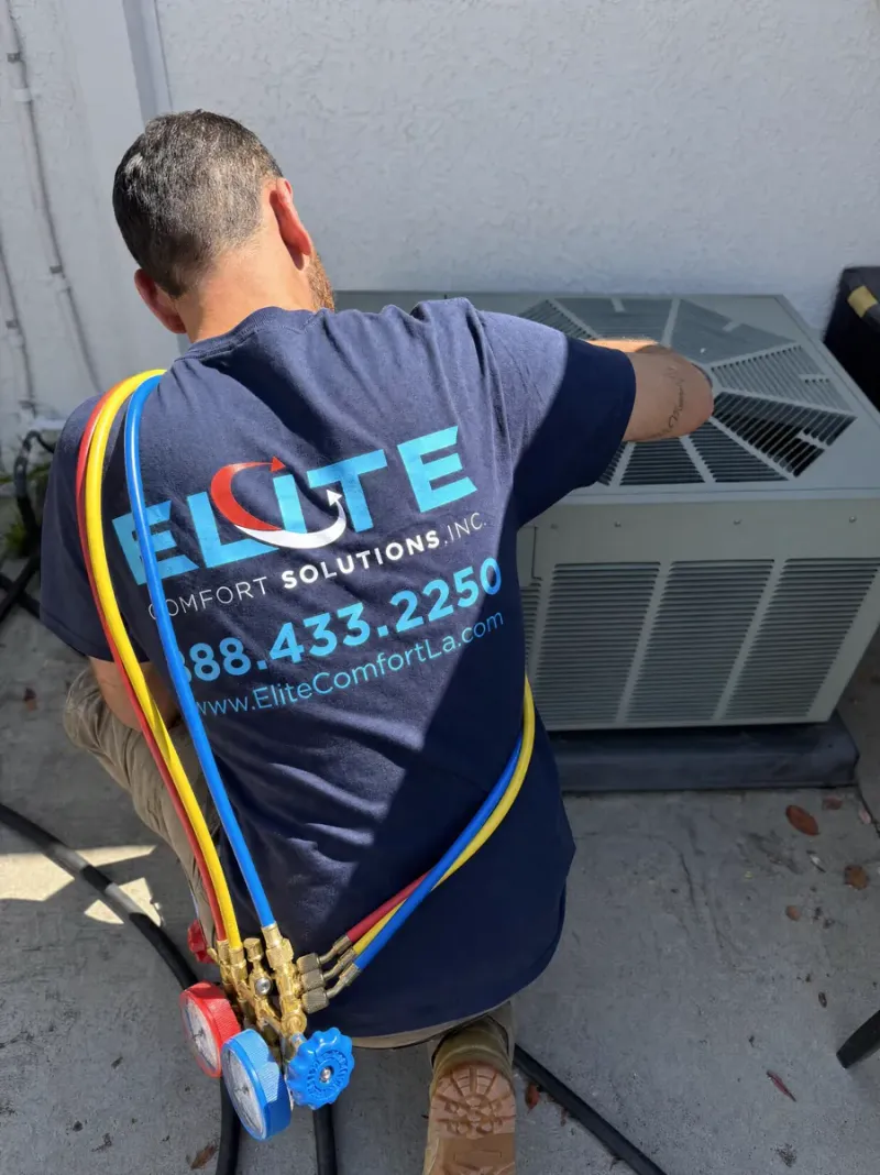 Elite Comfort technician charging and commissioning a heat pump with refrigerant manifold gauges